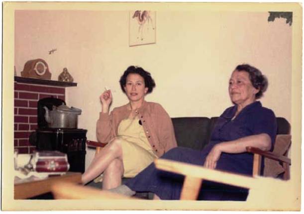 Agnes met haar dochter Yvonne in haar huis in Harderwijk, ca 1961. De 'Chinees' op de schoorsteenmantel heeft eindelijk weer wat voorspoed gebracht {1960:Harderwijk, Nederland}