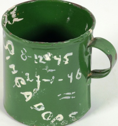 Mok van groen emaille, beschilderd door Ineke. De mok gebruikte Ineke in Nee-Soon van 8-12-45 tot 27-1-46, de periode waarin ze met haar ouders in het Irenekamp verblijft {1945:Nee-Soon; Yishun, Maleisië}
