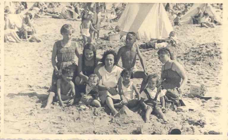 Den Haag, 1955. Lyke met haar grootgezin: pleeg-, stief- en eigen kinderen op het strand van Scheveningen, Nederland Hoe ze hier nu beland is? {1955:Scheveningen}